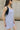 Close up side view of model wearing the Ariana Grey Romper. This is a grey romper, sleeveless, with pockets.