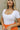 Close up view of model wearing the Kendra Square Neck Padded Bodysuit in white. This is a bodysuit with a square neckline, thong button closure, and short sleeves., comes in either black or white.