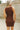 Close up back view of model wearing the Laila Mini Sweater Dress in chestnut. This is a sweater mini dress, sleeveless, comes in either black or chestnut.