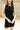 Close up view of model wearing the Laila Mini Sweater Dress in black. This is a sweater mini dress, sleeveless, comes in either black or chestnut.