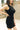 Close up side view of model wearing the Laila Mini Sweater Dress in black. This is a sweater mini dress, sleeveless, comes in either black or chestnut.