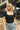 Close up of model wearing the Kendra Square Neck Padded Bodysuit in black. This is a bodysuit with a square neckline, thong button closure, and short sleeves., comes in either black or white.