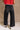 Lower body back view of female model wearing the Ceros: Florence Black Wide Leg Jeans with a red top.