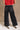 Lower body back view of female model wearing the Ceros: Florence Black Wide Leg Jeans with a red top.