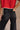 Close-up back view of female model wearing the Ceros: Florence Black Wide Leg Jeans with a red top.
