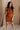 Front view of female model wearing the Monica Rust Mock Neck Sweater Dress that has rust colored knit fabric, a mock neck, and mini length hem.