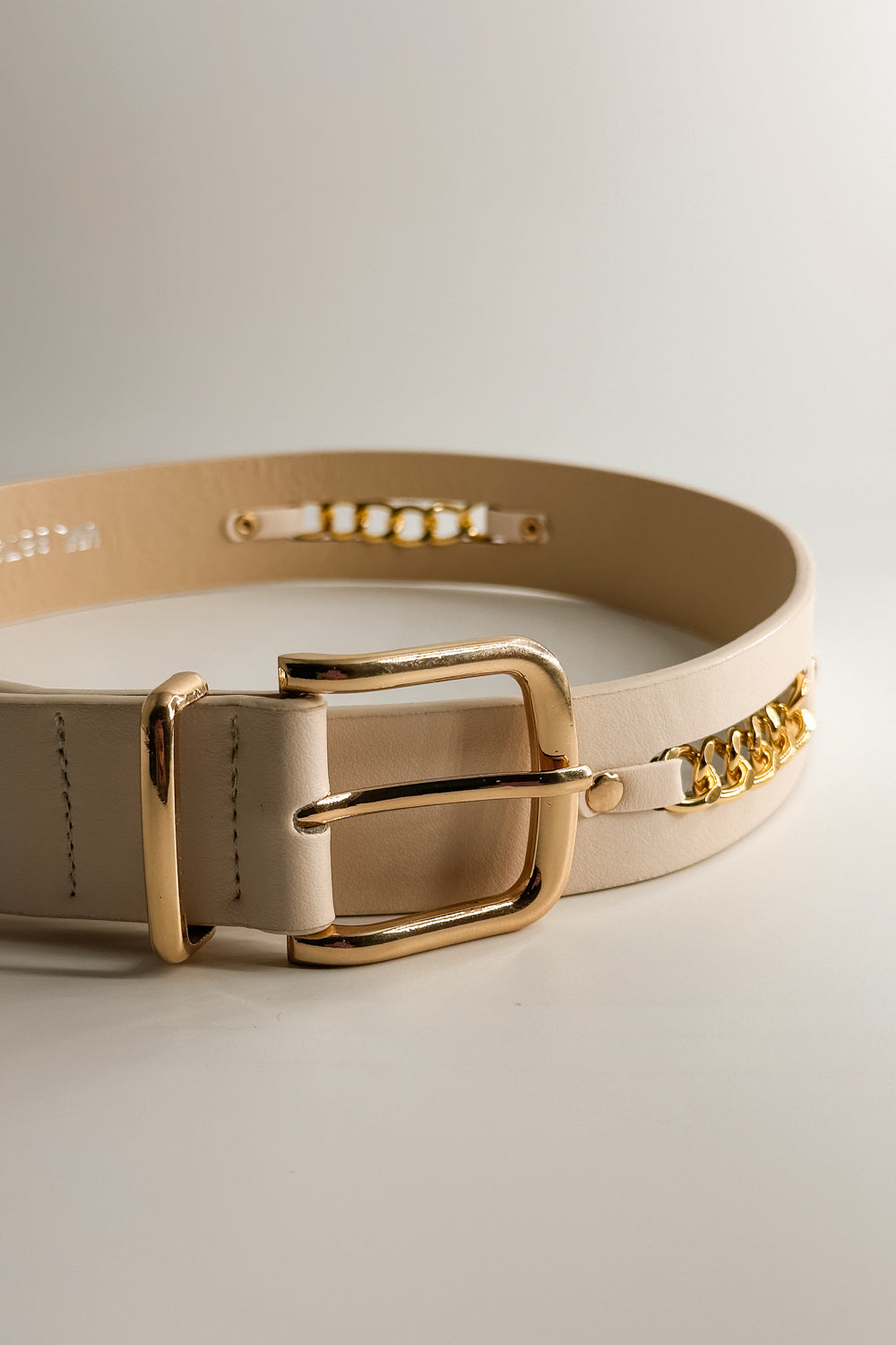 Front view of the Bella Ivory Gold Chain Belt which features ivory fabric, gold chain details and gold adjustable buckle.