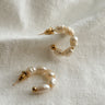 Flat lay view of the Meadow Mini Pearl Hoop Earring which features  mini, open gold hoops with pearls 
