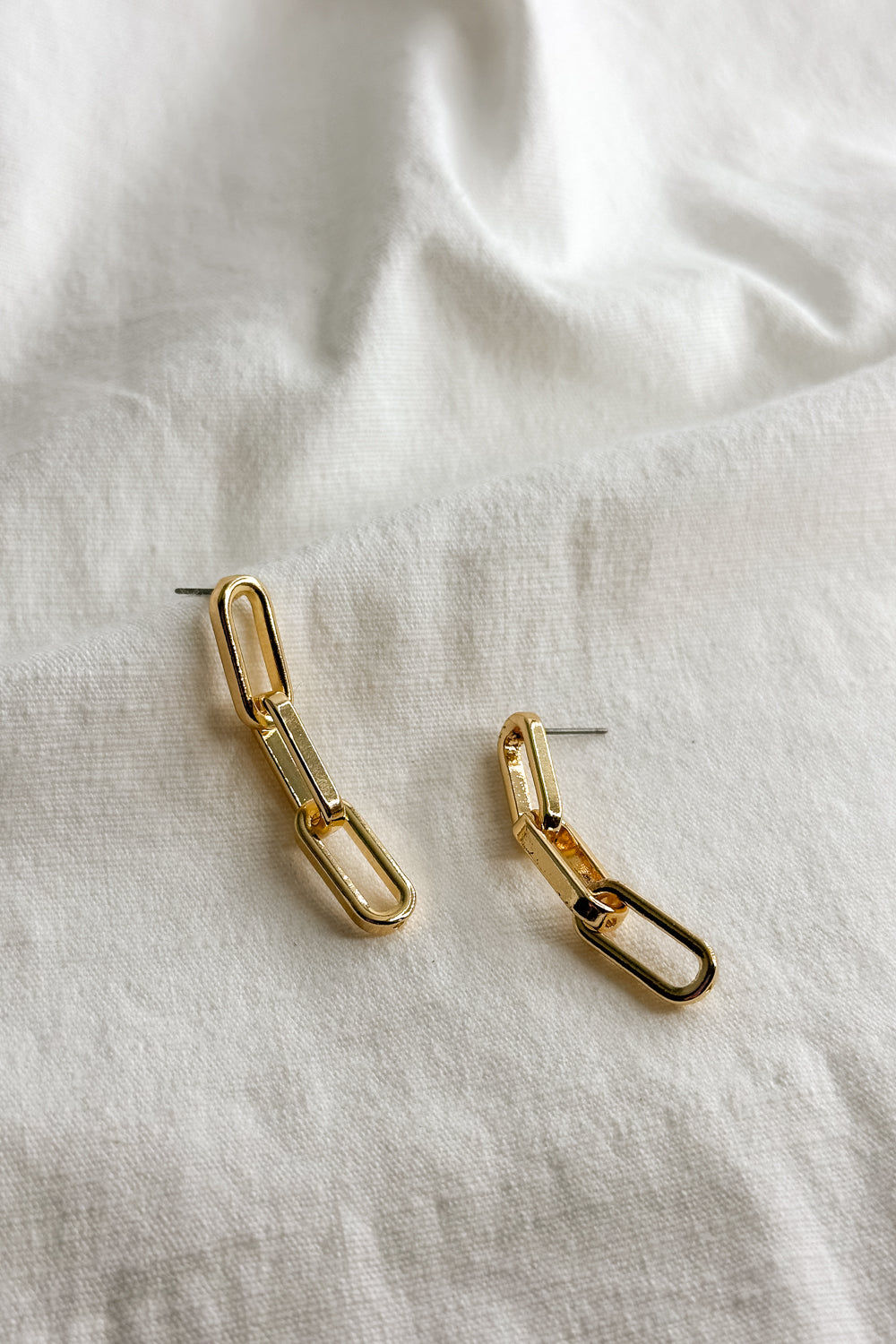 Flat lay view of the Emma Gold Chain Dangle Earring which features gold chain link dangle earrings
