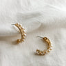 Flat lay view of the Elisa Gold Rope & Pearl Hoop Earring which features gold rope hoops with pearls 