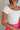 Close up view of female model wearing the Reign Off White Short Sleeve Bodysuit which features Off White Lightweight Fabric, Off -The-Shoulder Neckline and Short Sleeves