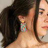 Side view of female model wearing the Julia Cork Multi Dangle Earring which features cork dangle earrings with multi color spots design