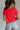 Back view of female model wearing the Evie Red Coral Short Sleeve Top which features Coral Red Cotton Fabric, Cropped Waist with Raw Hem, Round Neckline and Short Sleeves