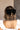 Image shows back of model's hair. Model is wearing the Stacia Velvet Hair Bow in Black that features black velvet fabric with gold dot embellishments and a clasp closure.