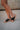 Right side view of female model wearing the B.O.C. Born Concept Sunny Wedge Sandal in Black which features Black Faux Leather Upper, Slip-On Style and Criss-Cross Strap & Toe Wrap Detail