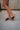 Right side view of female model wearing the B.O.C. Born Concept Sunny Wedge Sandal in Black which features Black Faux Leather Upper, Slip-On Style and Criss-Cross Strap & Toe Wrap Detail