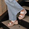 Front side view of female model wearing the Surrey Platform Sandal in Ivory which features Ivory Leather Upper Straps, Adjustable Buckle Back Strap, Memory Foam and Ivory and Tan Texture Espadrille Sole
