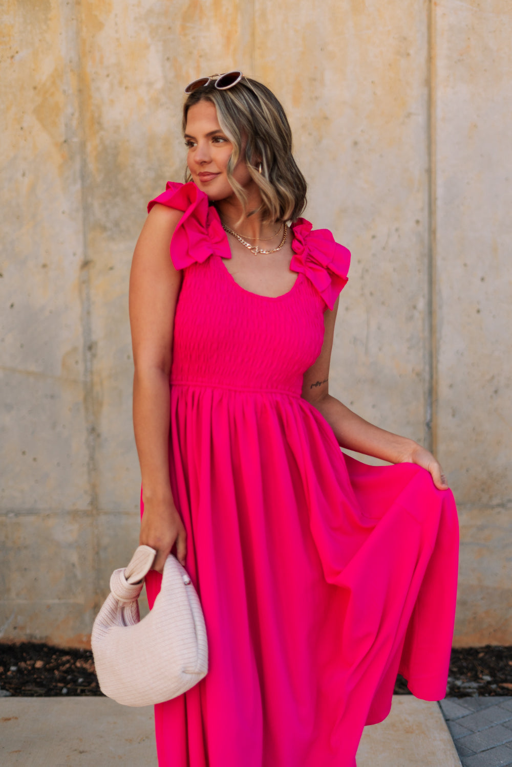 Front view of female model wearing the Kristina Pink Smocked Sleeveless Midi Dress that has hot pink fabric, side slit pockets, midi length, smocked upper, a scoop neckline, and ruffled straps.
