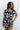 Upper body front view of female model wearing the Valerie Black & White Short Sleeve Romper that has a black and white abstract print, short sleeves, a collar, button up front, and elastic waist with tie.