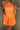 Front view of female model wearing the Amaya Strapless Flare Mini Dress in Orange which features Lightweight Fabric, Side Zipper Closure, Belt Loops, Two Front Pockets, Strapless and Shorts Lining. Worn with white belt