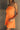 Front view of female model wearing the Amaya Strapless Flare Mini Dress in Orange which features Lightweight Fabric, Side Zipper Closure, Belt Loops, Two Front Pockets, Strapless and Shorts Lining. Worn with white belt