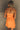 Back view of female model wearing the Amaya Strapless Flare Mini Dress in Orange which features Lightweight Fabric, Side Zipper Closure, Belt Loops, Two Front Pockets, Strapless and Shorts Lining. Worn with white belt
