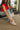 Side view of female model wearing the Steve Madden Madrid Silver Sneakers with jeans and a red top.
