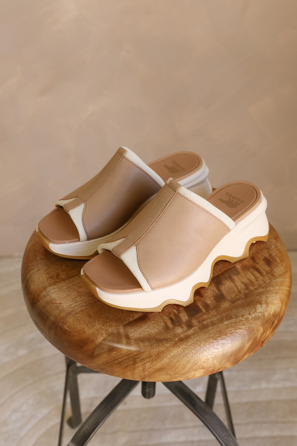 Side view of the Kinetic Impact Slide High Wedge Sandal in Honest Beige & Honest White which features Sporty Slip-On Style, Beige and Cream Leather Upper, Two-Tone Scalloped Sole Detail, Molded Rubber Outsole, 2 1/4" Heel Height and 1 1/4" Platform Height