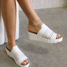 Side view of female model wearing the Venti Iris Sandal in White which features White Fabric Upper, Mesh Stripe Details,  Slide On Style, Memory Foam Footbed, 2.25 Inch Platform Wedge and Flexible Rubber Outsole