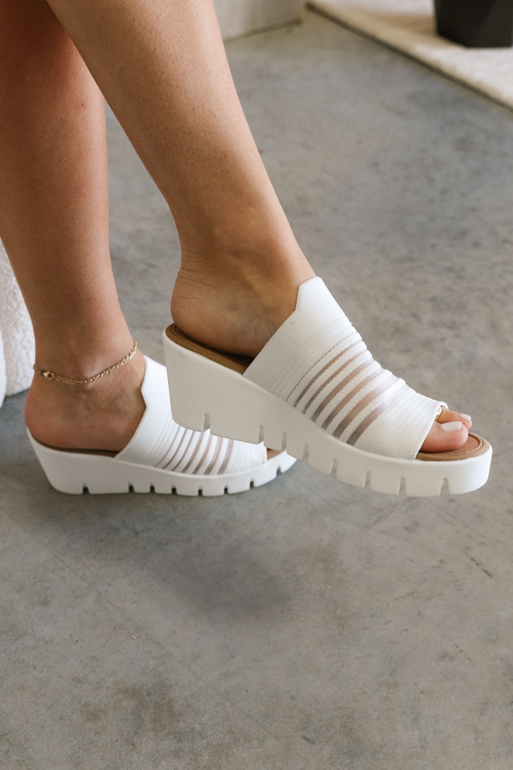 Close up side view of female model wearing the Venti Iris Sandal in White which features White Fabric Upper, Mesh Stripe Details, Slide On Style, Memory Foam Footbed, 2.25 Inch Platform Wedge and Flexible Rubber Outsole