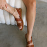 Ariel view of female model wearing the Kacee Sandal in Dark Brown which features Slingback Slide-On Style, Cushioned Footbed, Burnished Brown, Hand-Finished Upper, Round Toe, 0.5" Platform Height and 0.75" Heel Height