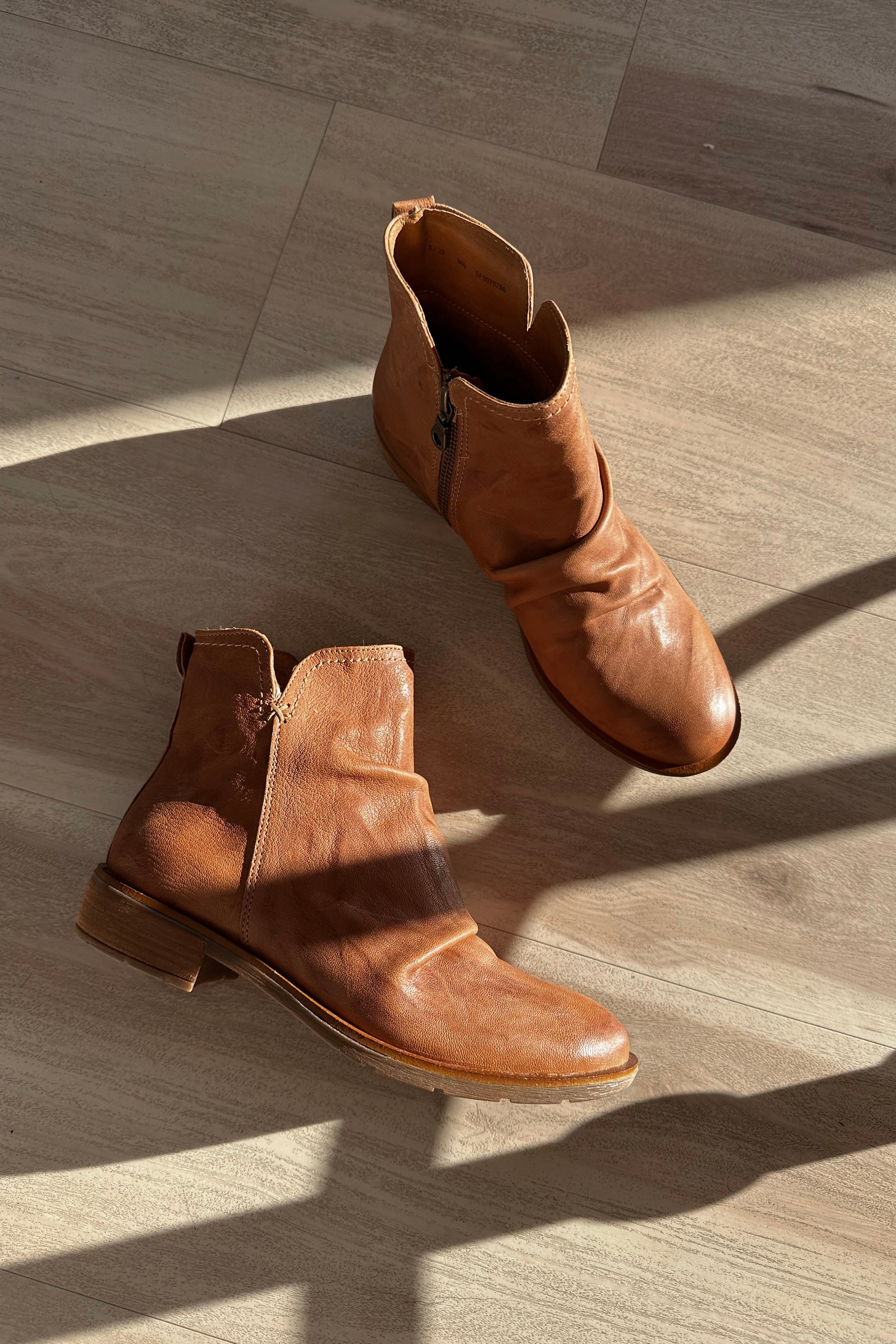 Ariel view of the Beckie Boot in Luggage which features light brown leather fabric, heel tab, cushioned footbed, slouched details and heel height is 1 1/2 inches