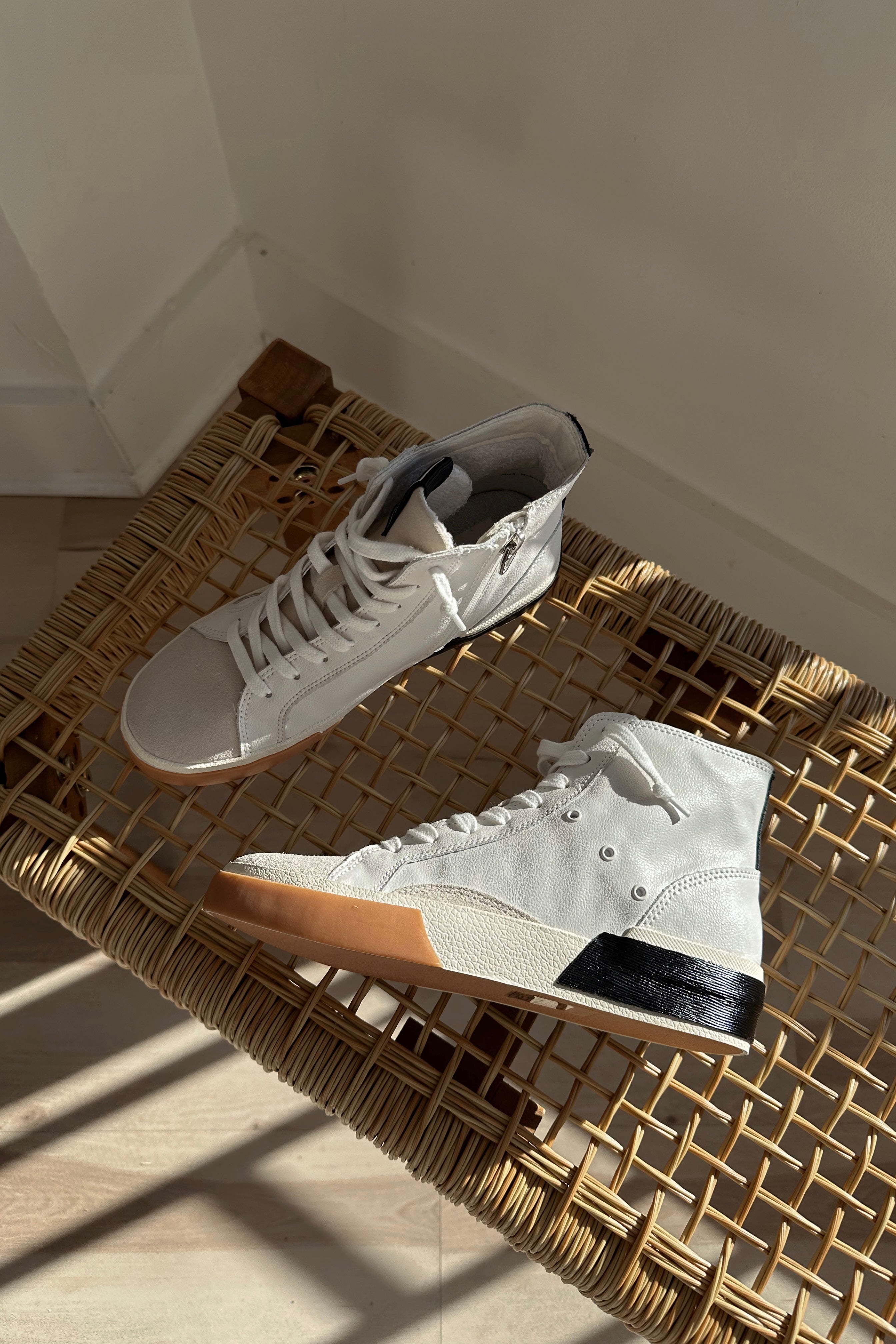 Flat lay view of the Zohara Sneaker in White Black Leather which features black, brown and white leather upper, off white suede upper, color-block design, high-top style, round toe, lace up details and back zipper closure 