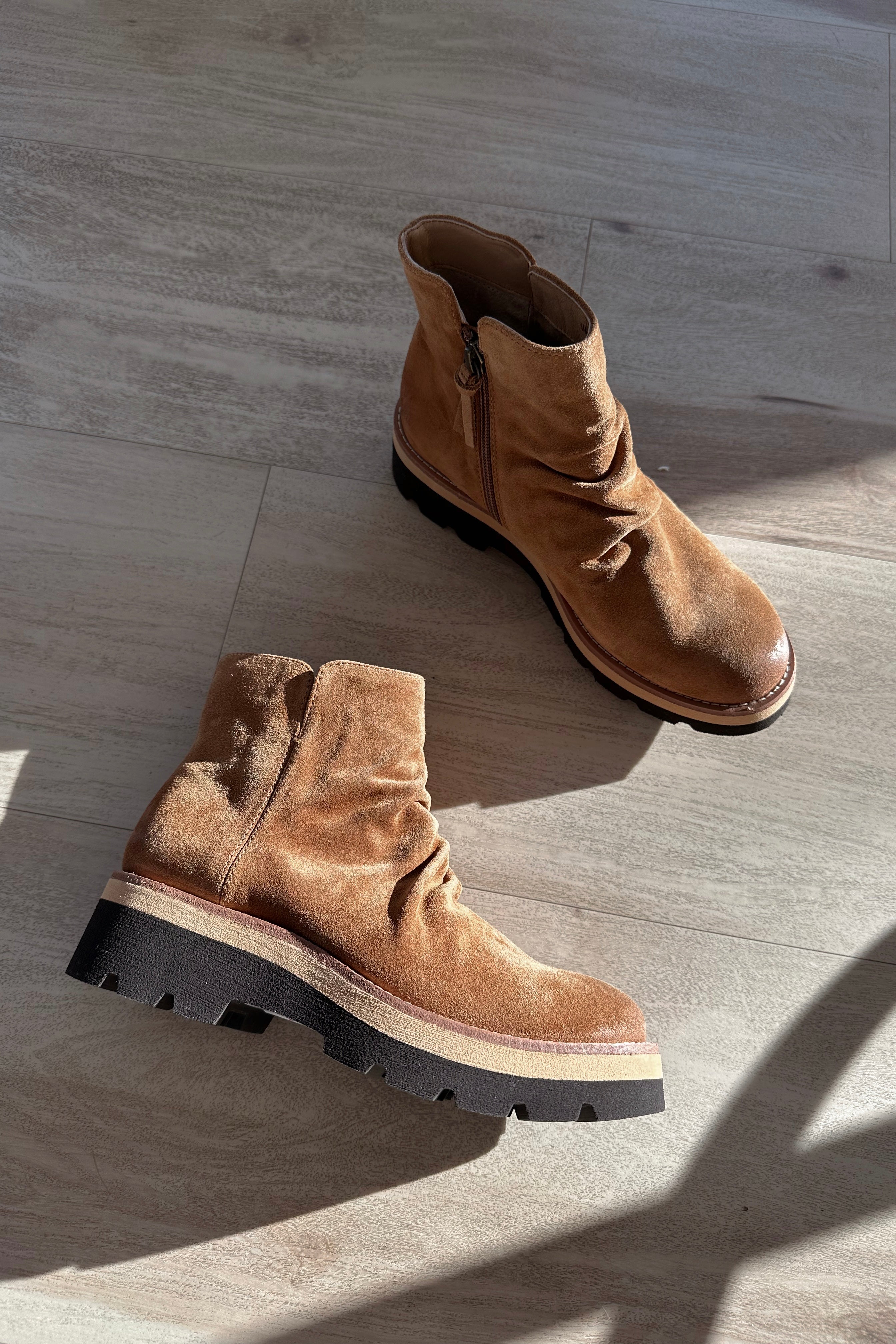 Ariel view of the Pecola Boot in Brandy which features light brown water-resistant suede fabric, slouch details, black lug sole, inside zipper, arch support and 2 inch heel height