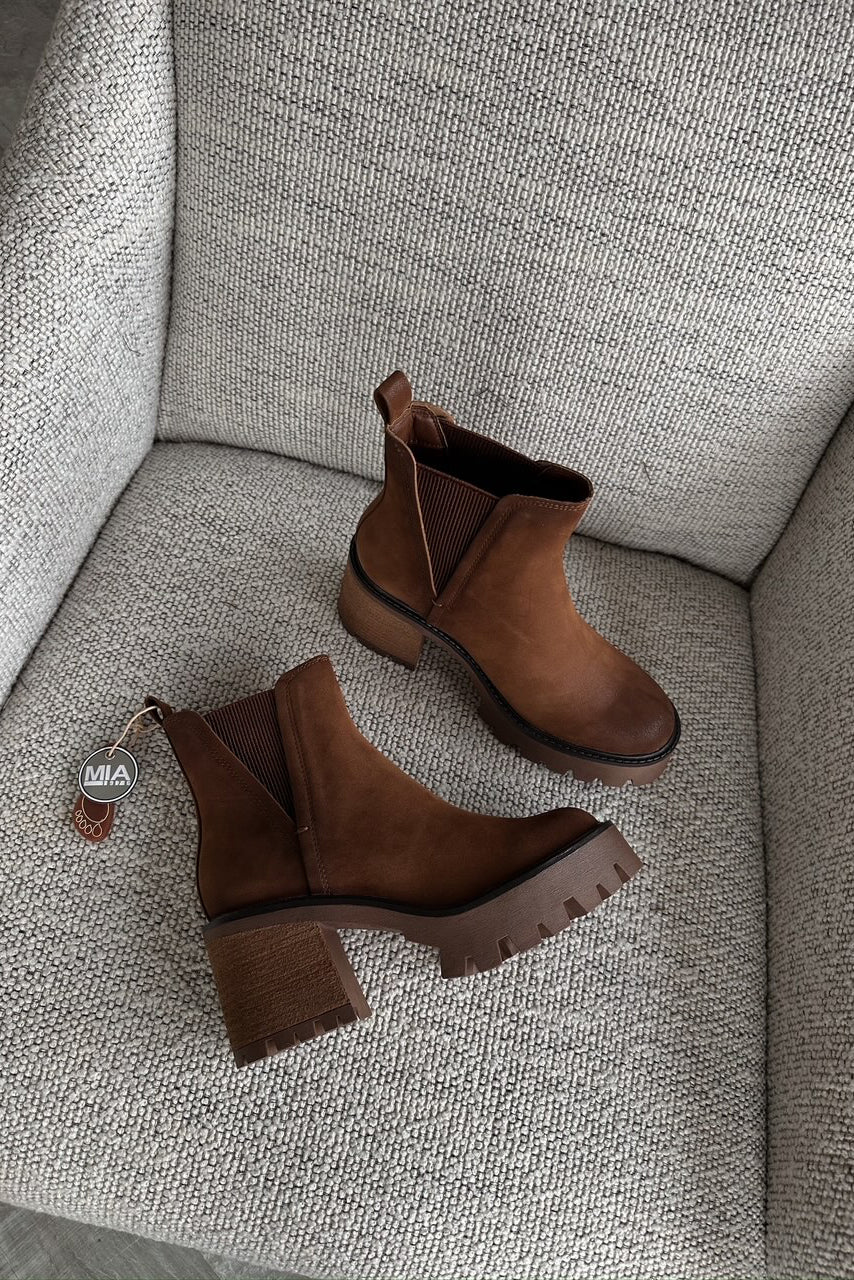 Flat lay view of Rusty Bootie in Cognac which features cognac suede fabric, round neckline, platform sole, block heel, and pull tabs