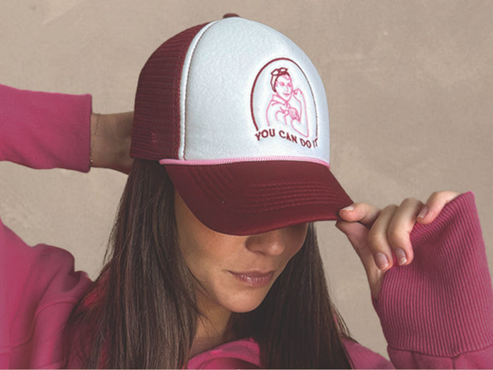 Image of woman in a pink pullover wearing a "you can do it" hat