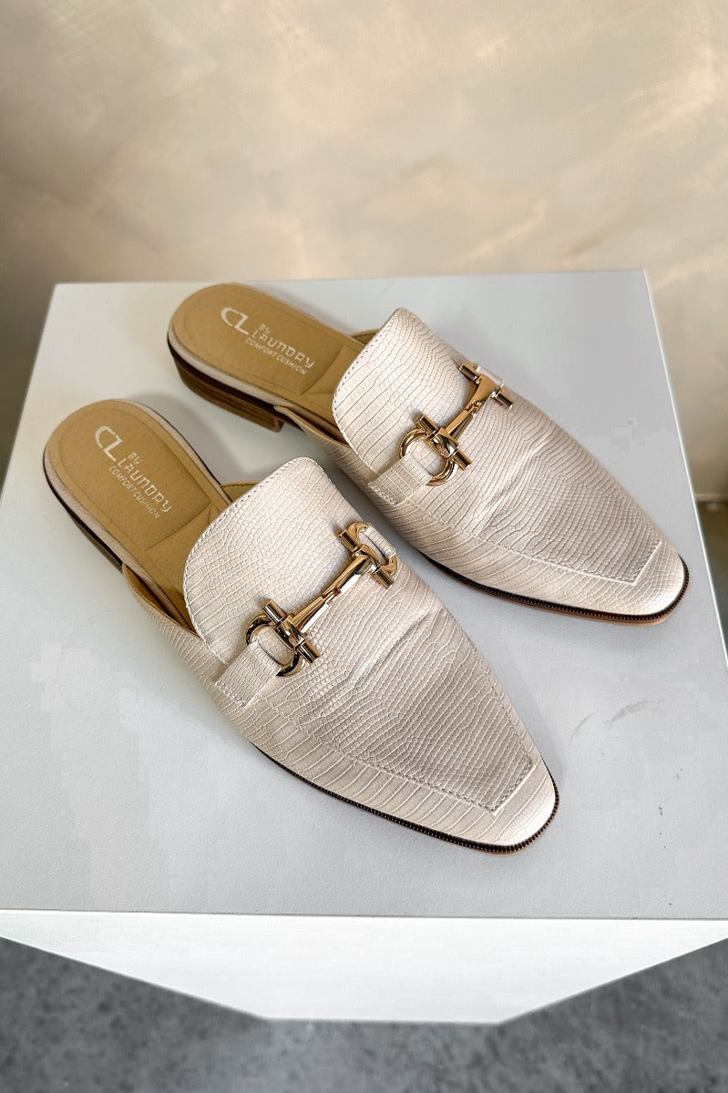 Ariel view of the Score Lizard Cream Gold Buckle Mule which features cream snakeskin faux-leather, a gold buckle detail, backless slide entry, and a 1" heel.