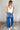 FUll body back view of model wearing the Ceros: Florence Medium Wash Wide Leg Jeans which features medium blue denim fabric, a front zipper with a button closure, belt loops, a super high-rise waist, two front pockets, two back pockets, and wide cropped l