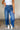 Front view of model wearing the Ceros: Florence Medium Wash Wide Leg Jeans which features medium blue denim fabric, a front zipper with a button closure, belt loops, a super high-rise waist, two front pockets, two back pockets, and wide cropped legs with 