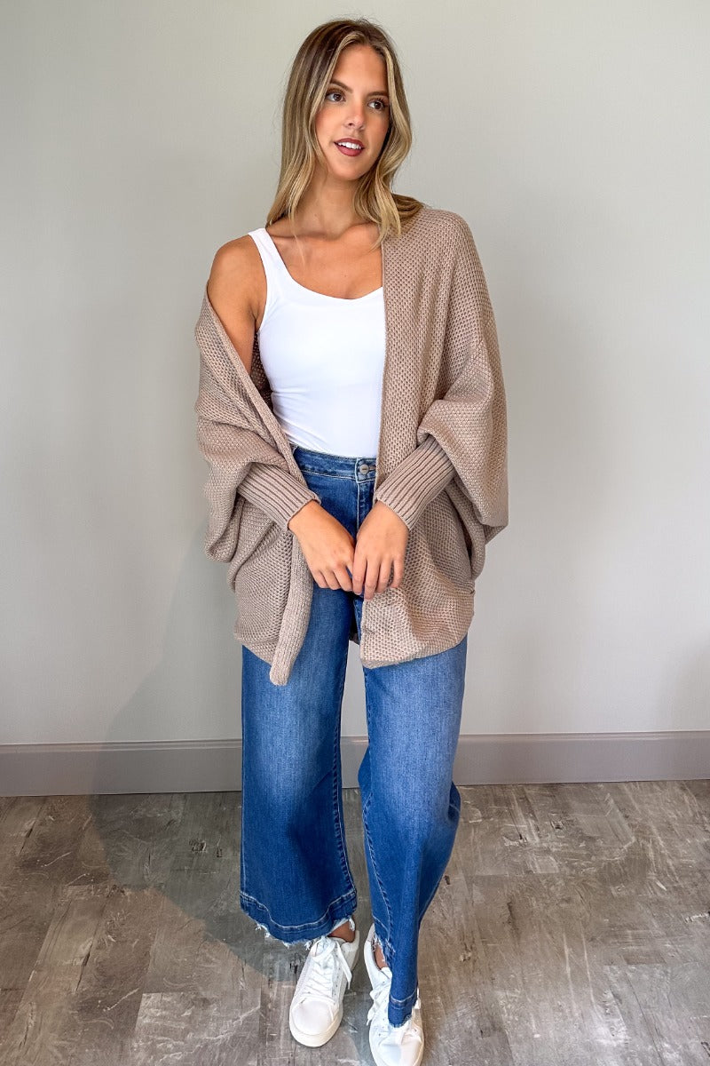 Full body view of model wearing the Jennifer Mocha Knit Long Sleeve Open Cardigan which features light mocha knit fabric, front open with no closure, ribbed hem details and long sleeves with cuffs.