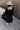 Full body back view of model wearing the Wrenley Black Long Sleeve Midi Dress which features black gauze fabric, a tiered body, midi-length hem, long balloon sleeves with elastic trim, side pockets, a v neckline, and a smocked back.