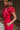 Side view of model wearing the Giana Hot Pink Wide Leg Ruffle Jumpsuit that has hot pink knit fabric, pockets, a ruffle details, a v-neck, a back zipper, and flare pant legs.