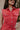 front detail image of modeal wearing The Emily Washed Red Denim Sleeveless Romper features washed red denim fabric, two front pockets, silver button details, button-up front, two front chest buttoned pockets, two back pockets, a collared neckline and a sl