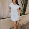 Full body view of model wearing the Sienna White Knit Mini Dress which features off white knit fabric with a monochrome block stripe design, mini length, two slit side pockets, a left front chest pocket, a round neckline and sleeveless.
