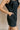 Close up view of model wearing the Avril Black Denim Ruffle Sleeveless Romper which features black washed denim fabric, pockets on each side, a front zip up, an elastic waistband, a square neckline, and ruffle straps.