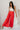 Full body view of model wearing the Scarlett Red Wide Leg Pants which features red lightweight fabric, two front pockets, a front zipper with a hook closure, belt loops and wide legs.