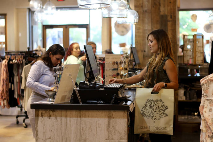 image of employee checking a customer out with their purchase behind a counter in the store