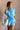 Front view of model wearing the Delilah Washed Sky Blue Short Sleeve Romper which features washed light blue tencel fabric, two front slit pockets, an elastic waistband with a drawstring tie, a right front chest pocket, tortoise button closures, a collare