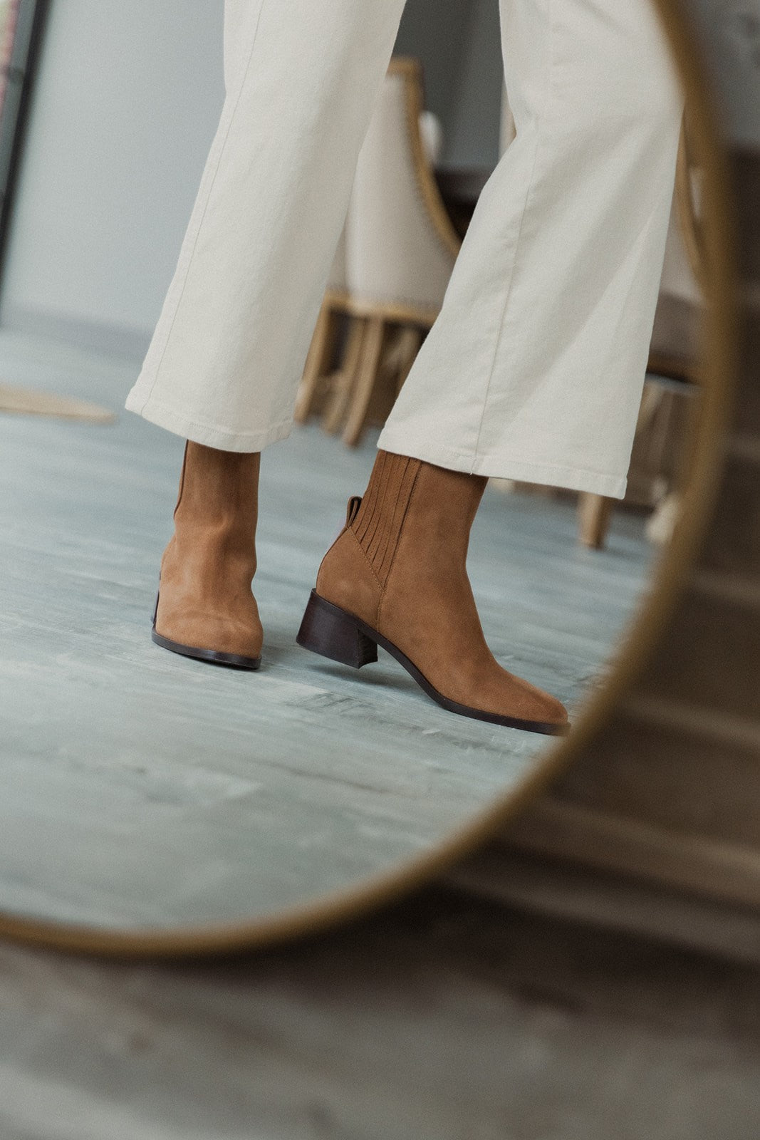Side view of female model wearing the Linny H2O Boot in Brown Suede H2O which features cognac suede upper fabric, round toe, tall shaft, block heel and pull on tab