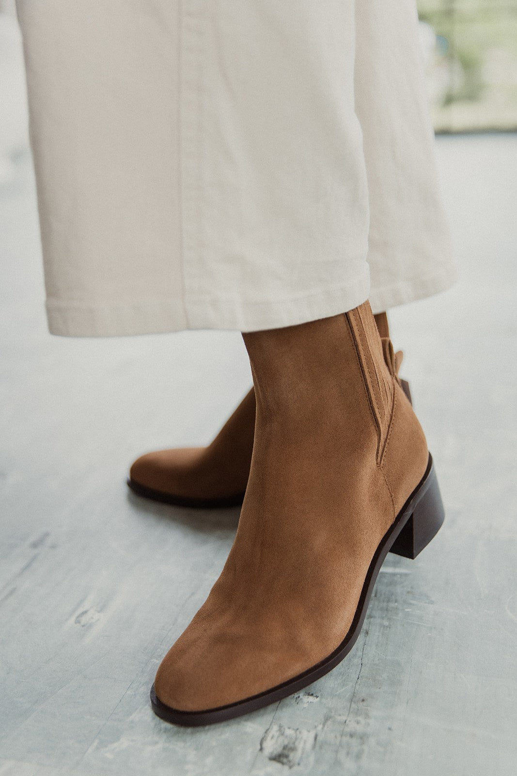 Front angle view of female model wearing the Linny H2O Boot in Brown Suede H2O which features cognac suede upper fabric, round toe, tall shaft, block heel and pull on tab